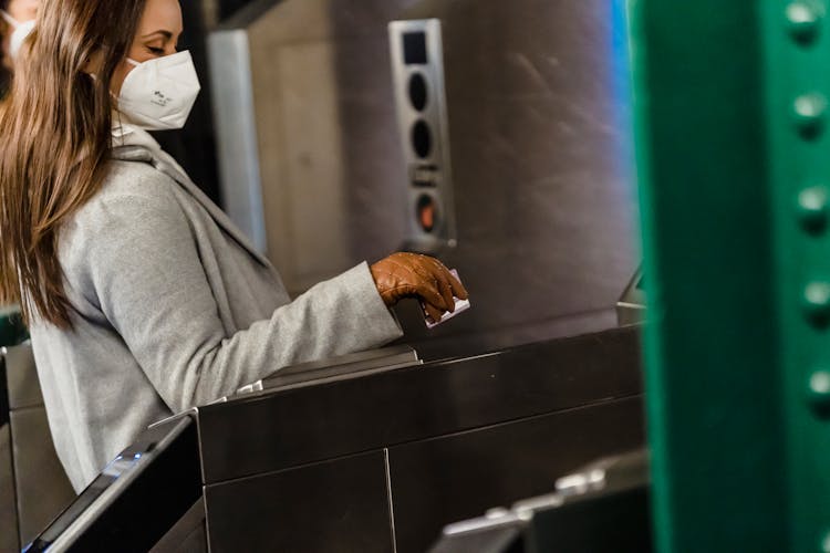Crop Woman In Mask Passing Through Turnstile In Metro