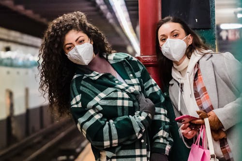 Free Ladies in masks on subway station with phone Stock Photo