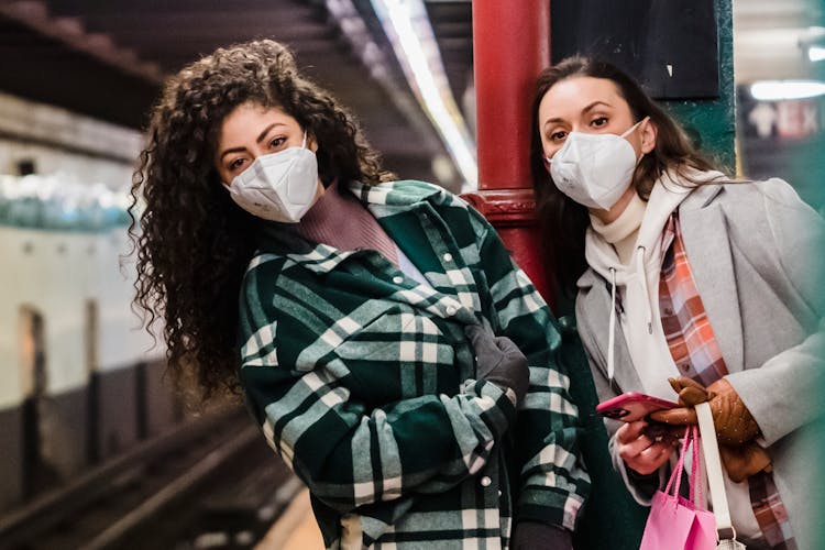 Ladies In Masks On Subway Station With Phone