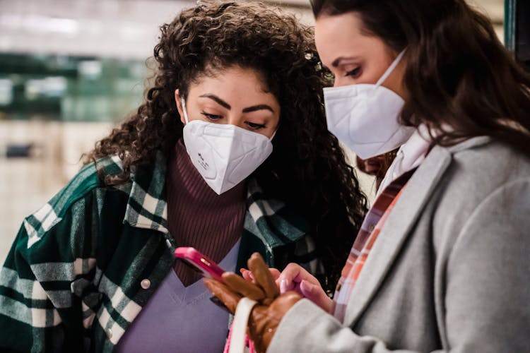 Ladies In Masks Checking Information On Phone On Subway Station