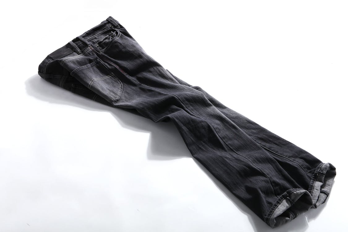 Free Black Denim Jeans on White Panel Stock Photo