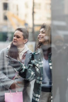 Two women shopping together, looking at a store display with smiles.