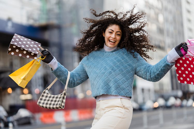 Happy Woman Jumping With Shopping Bags