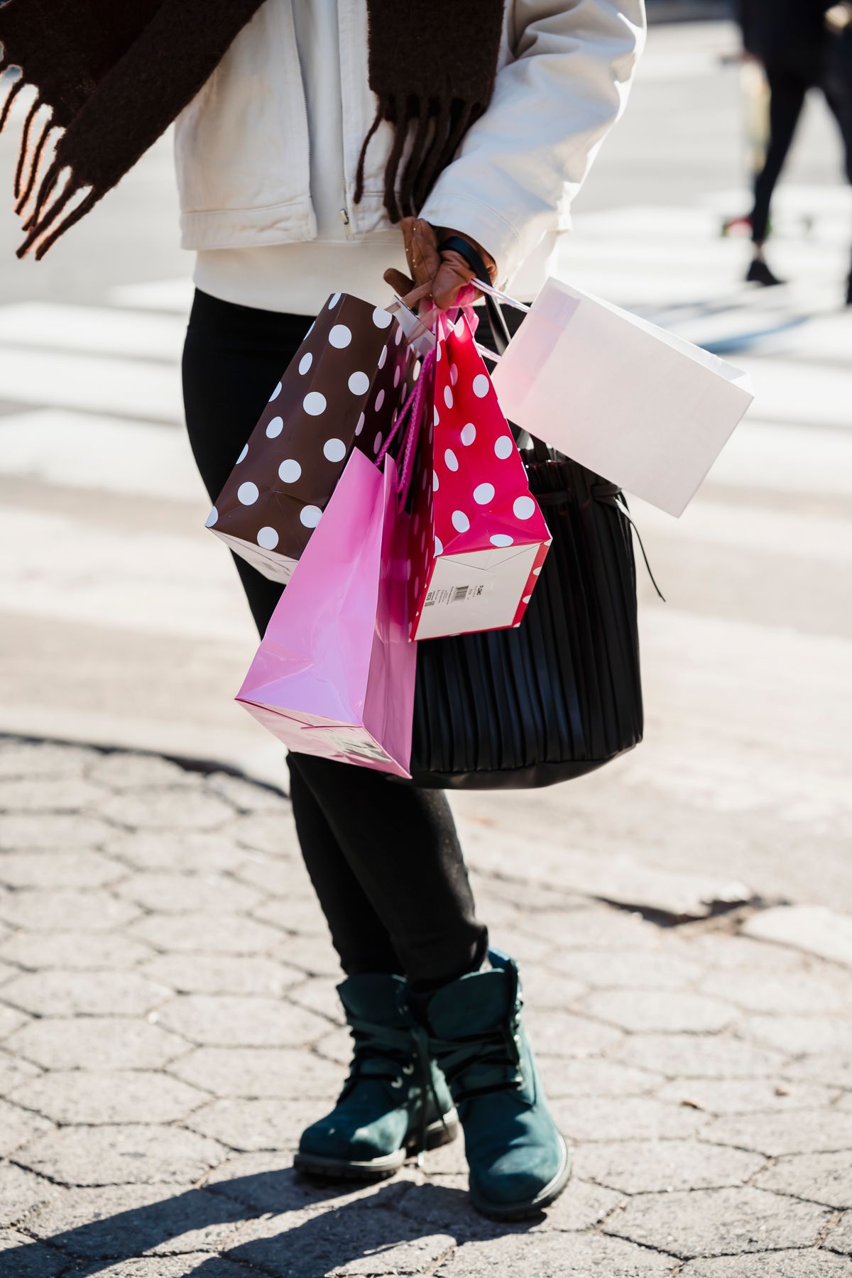 Woman carrying several shopping bags on a city street