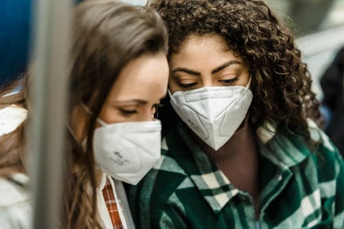 Free Young women in medical masks riding in subway Stock Photo