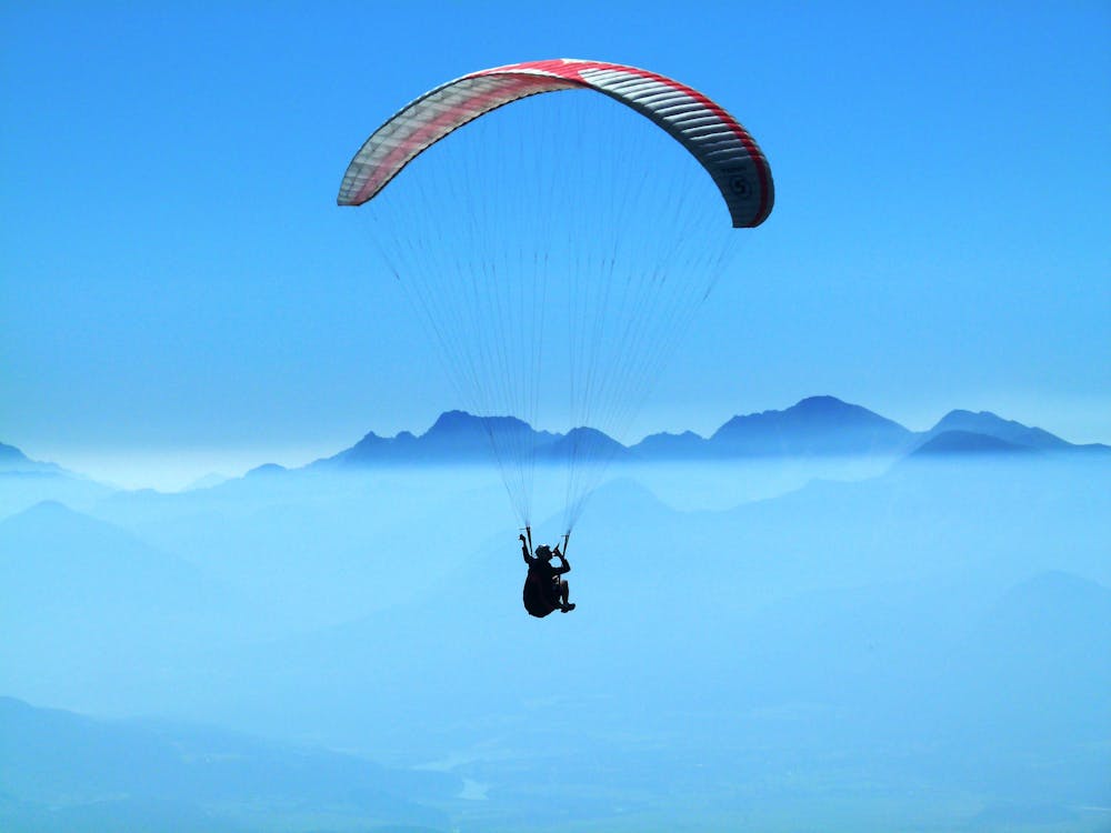 免费 白天在云层上方做滑翔伞的人 素材图片