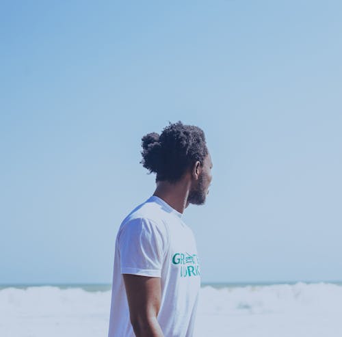 Black man admiring foamy ocean in stormy weather