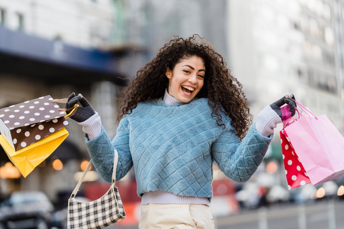 Free Happy ethnic woman demonstrating shopping bags Stock Photo