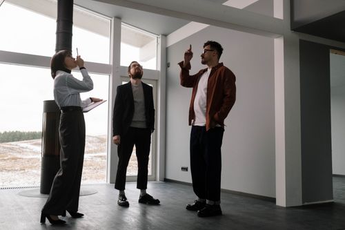 Free Three real estate agents discussing design in a modern apartment space. Stock Photo