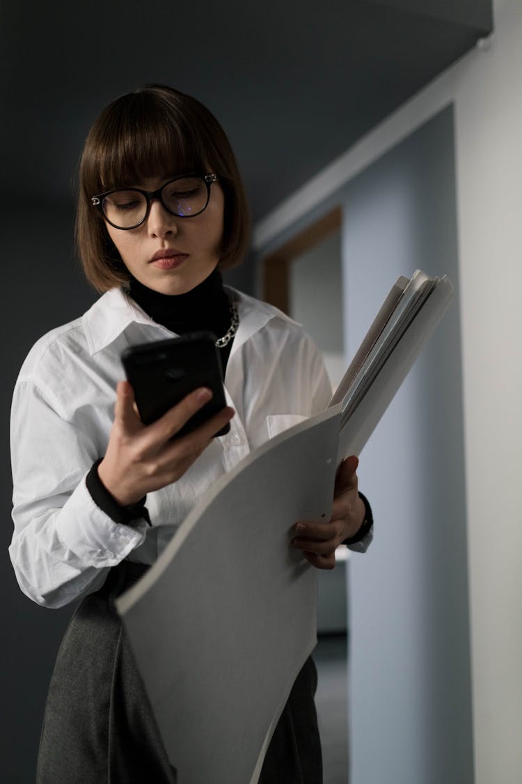 Woman In White Long Sleeves Looking At Her Smartphone 