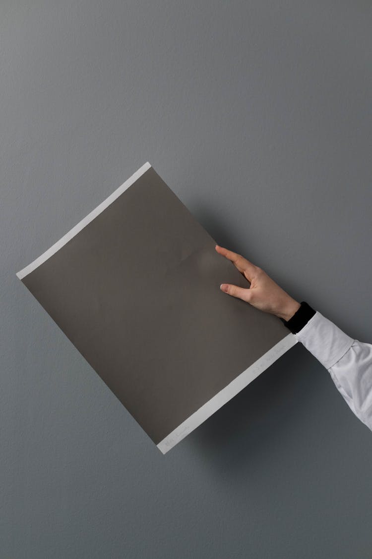 Person Holding A Gray Cardboard