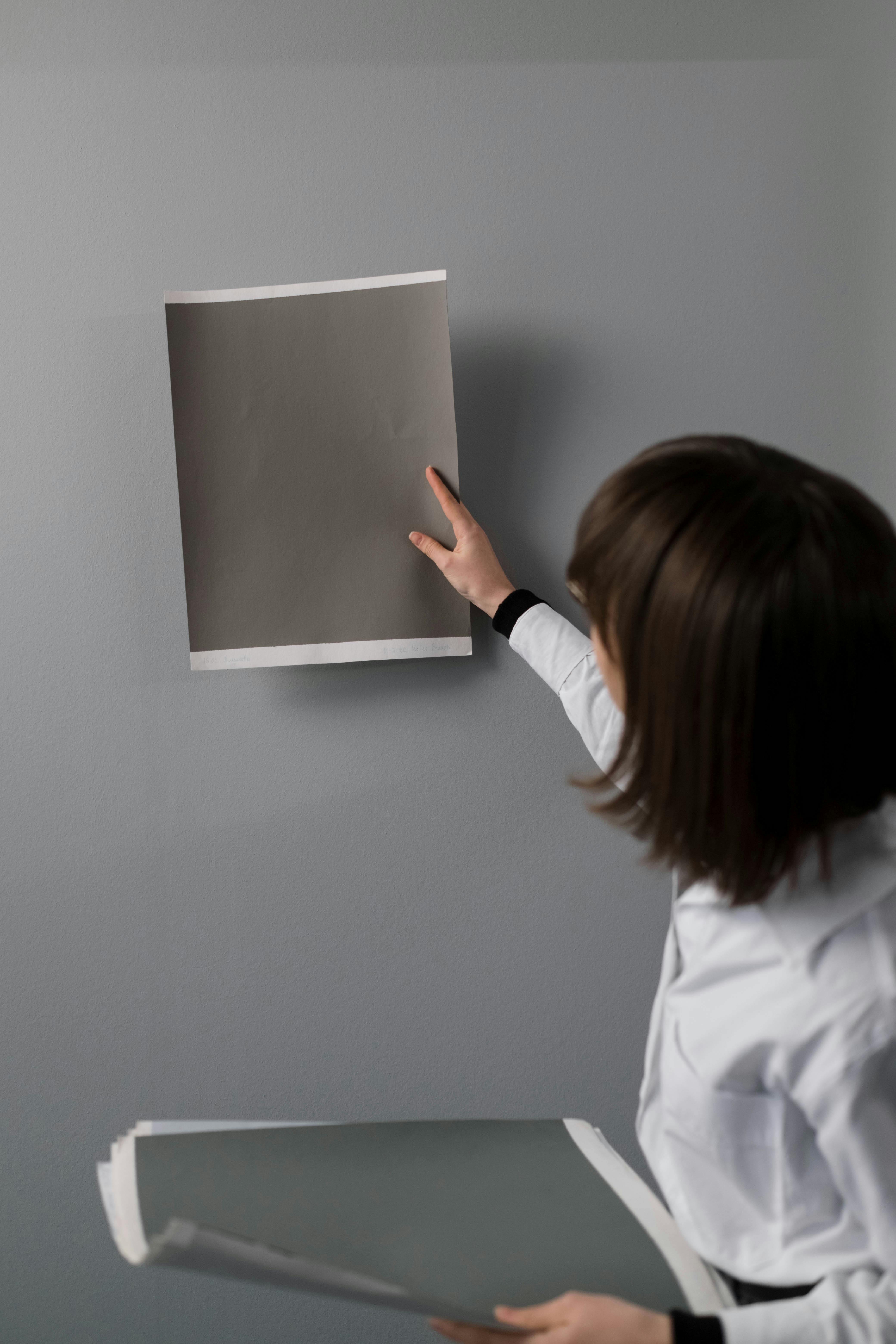 a woman in white long sleeve shirt holding gray papers