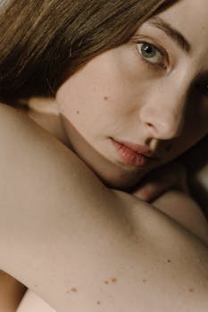 Close-up portrait capturing the serene expression of a woman embracing natural beauty.