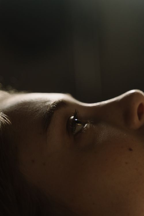 Free A close-up shot of a woman's face lying down, capturing emotion and detail. Stock Photo