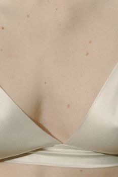 Intimate close-up of a woman wearing elegant silk lingerie, highlighting texture and detail.
