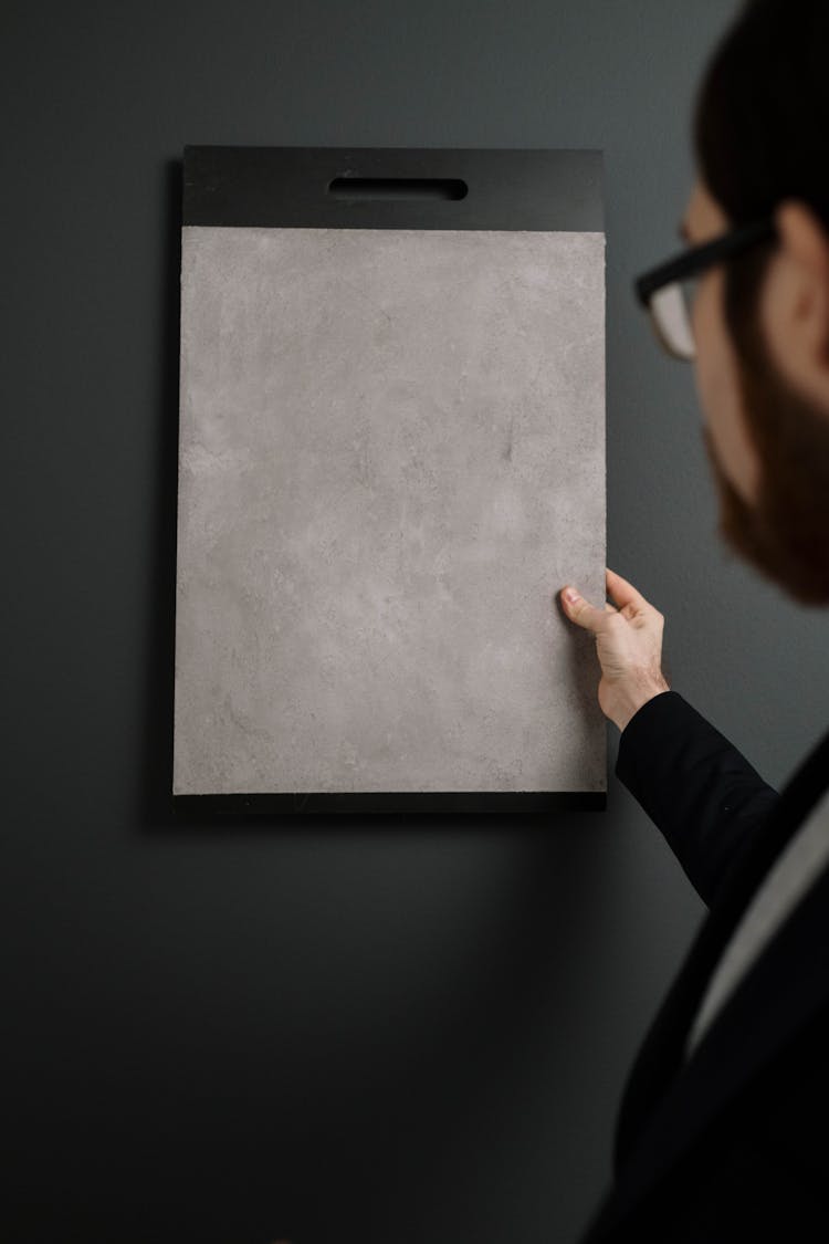 Man Testing A Sample Colour Against A Wall