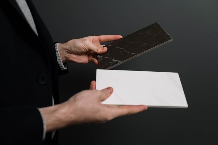 White And Black Marble Tiles In Hands