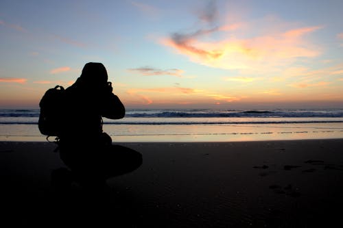 Kostenlos Schattenbild Der Person, Die Foto Nahe Ozean Nimmt Stock-Foto
