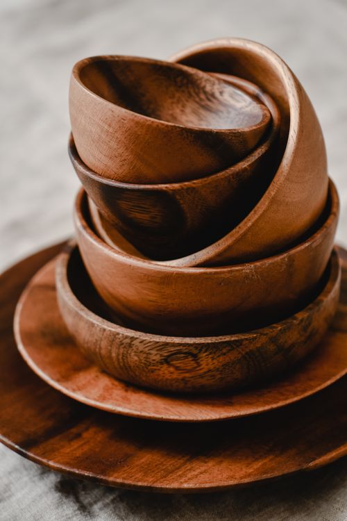 Free Aesthetic close-up of stacked wooden bowls and plates in a Japandi style. Stock Photo