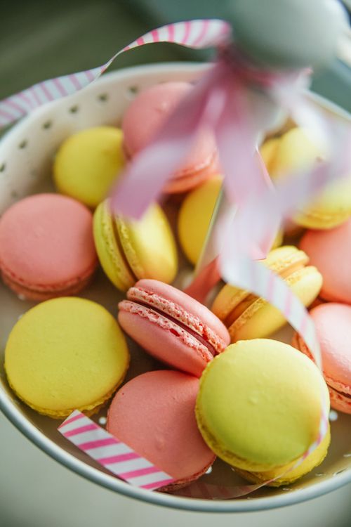 Free A vibrant display of pink and yellow macarons on a ceramic plate, perfect for dessert ideas. Stock Photo