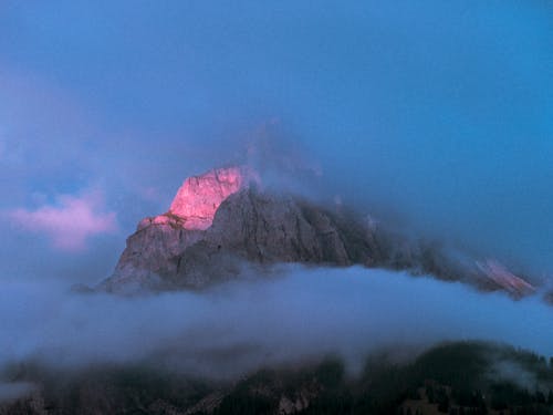 Free Clouds Covering a Rocky Mountain Stock Photo