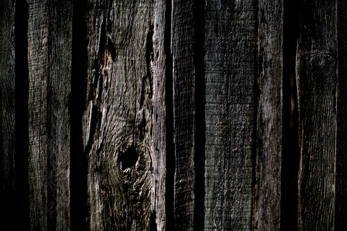 Free A close-up of a weathered wooden fence showcasing texture and natural knot patterns. Stock Photo