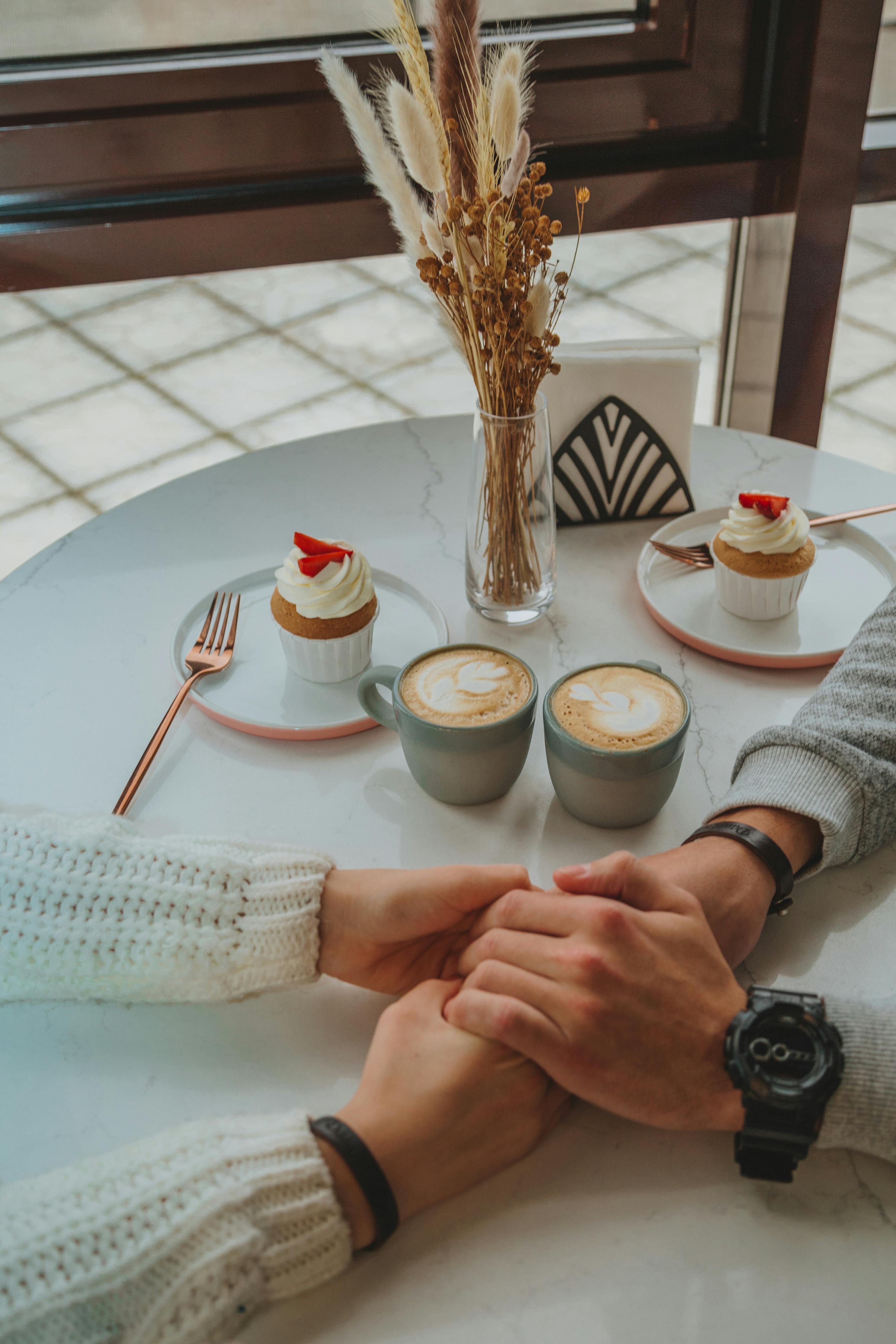 crop loving couple holding hands in cafe