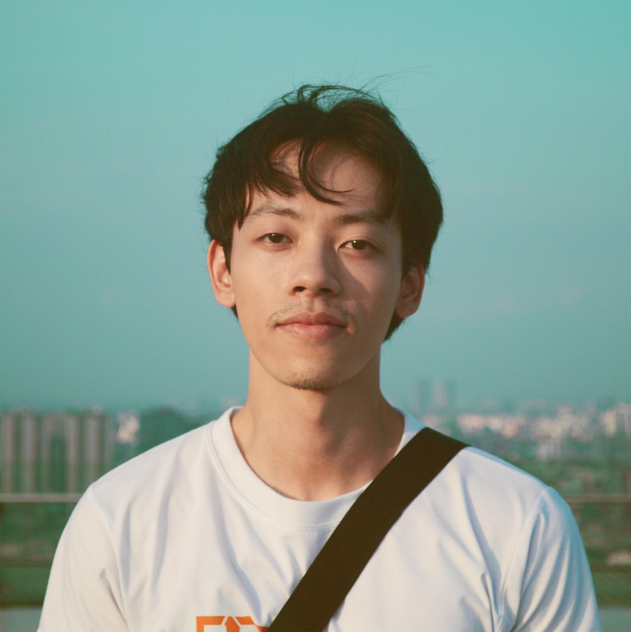 Young Asian man with a thoughtful expression enjoying the day in Hanoi.