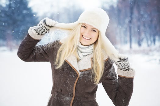 A cheerful woman enjoying winter, wearing a stylish coat and hat, outdoors in the snow.