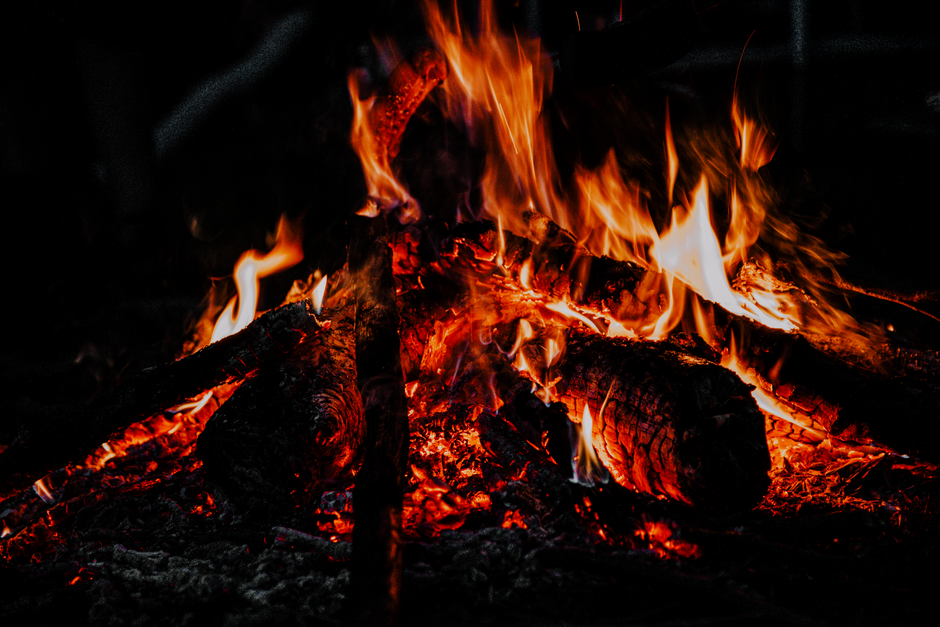 Cozy bonfire flames glowing in the night, perfect for a comforting outdoor ambience.
