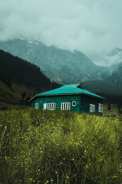 Green Wooden House on the Grass Field