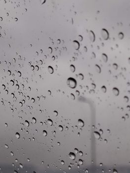 Detailed view of raindrops on glass, creating a serene and abstract pattern.