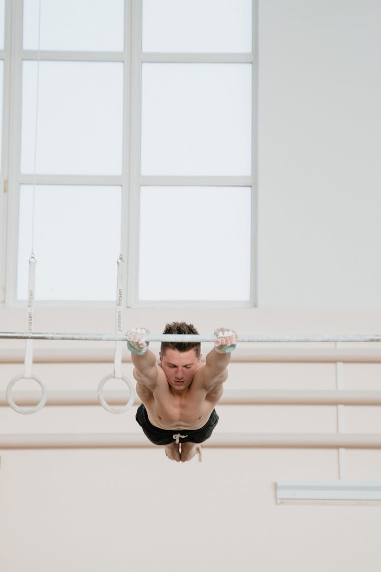 A Man Doing Gymnastics On A Parallel Bar