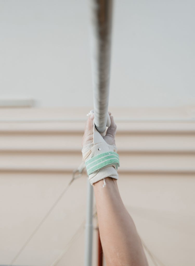 A Gymnast Gripping Onto A Parallel Bar