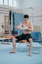 Topless Man in Black Shorts Sitting on Blue Exercise Ball