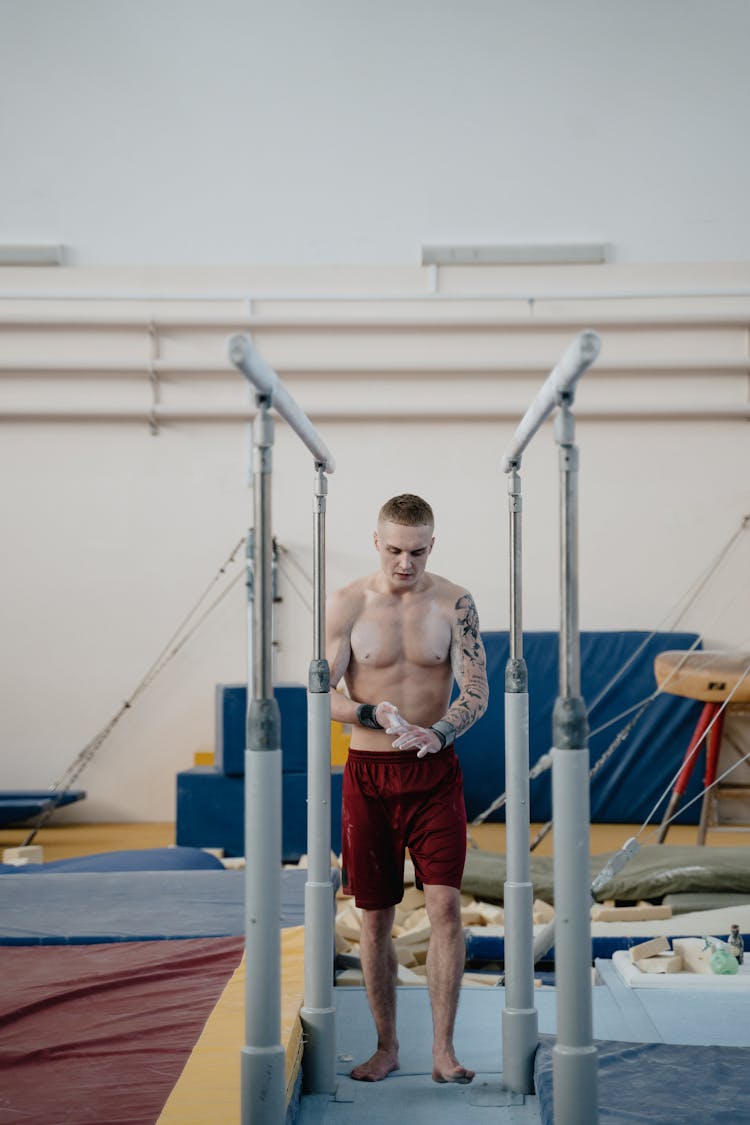 A Young Man Walking Towards Parallel Bars