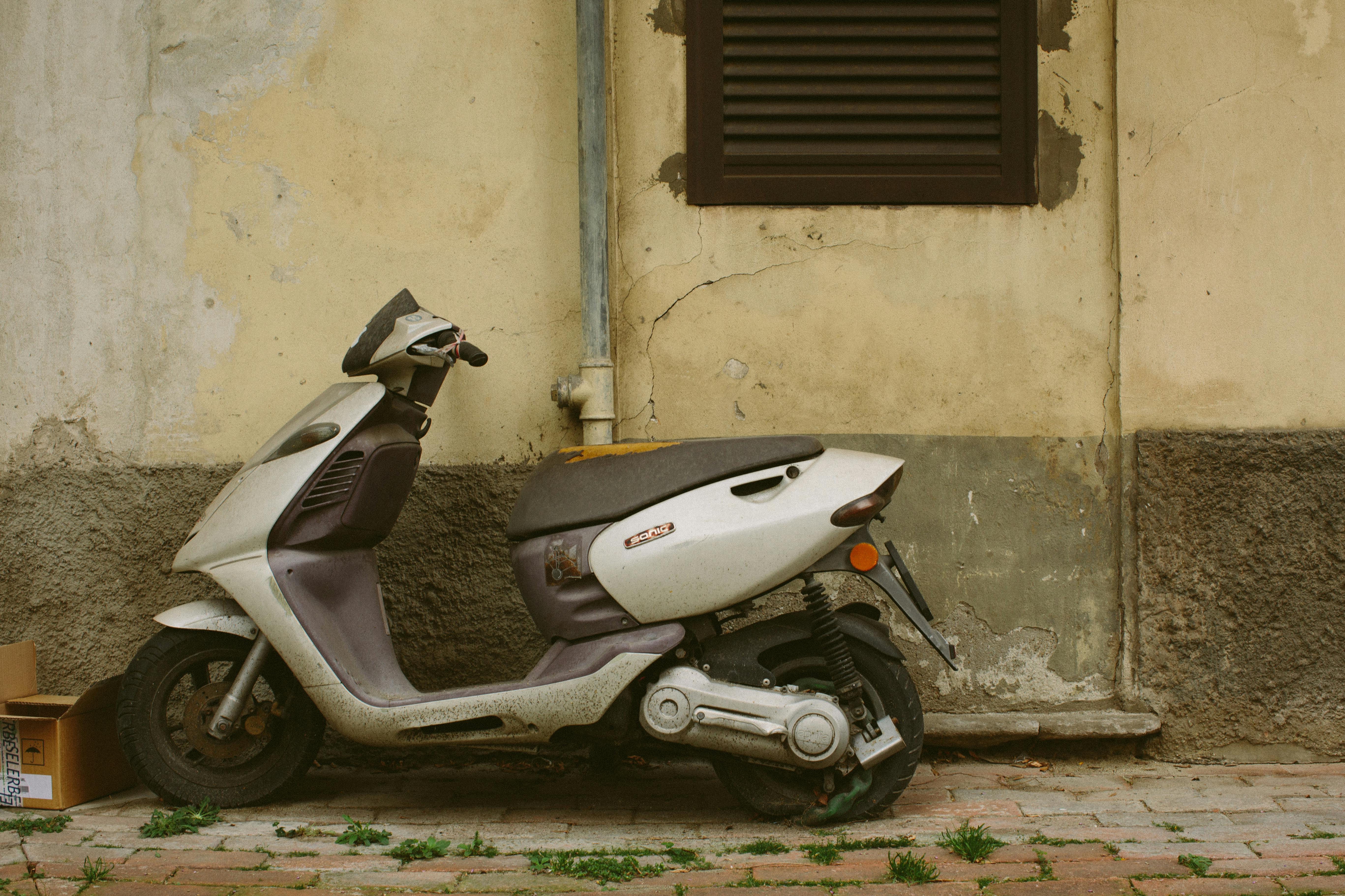 Abandoned Scooter Parked Beside The Wall · Free Stock Photo