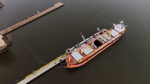 Free Drone view of metal ship with cargo on peaceful rippling water of river in daytime Stock Photo