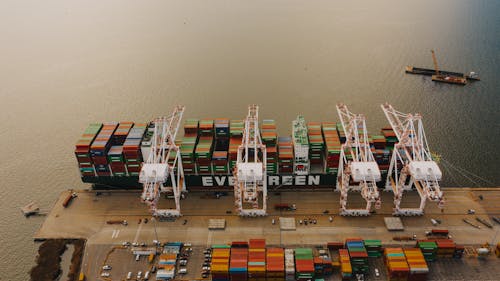 From above of many cargo containers on ship moored on calm water of river in daytime