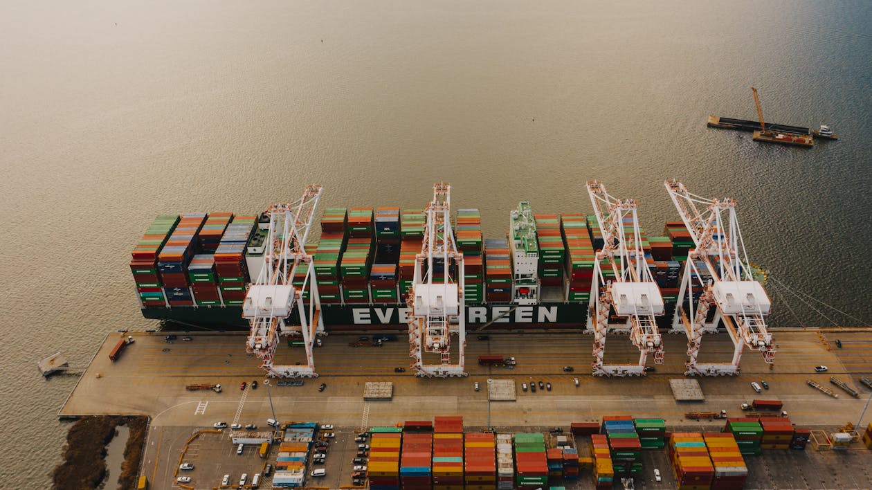 From above of many cargo containers on ship moored on calm water of river in daytime