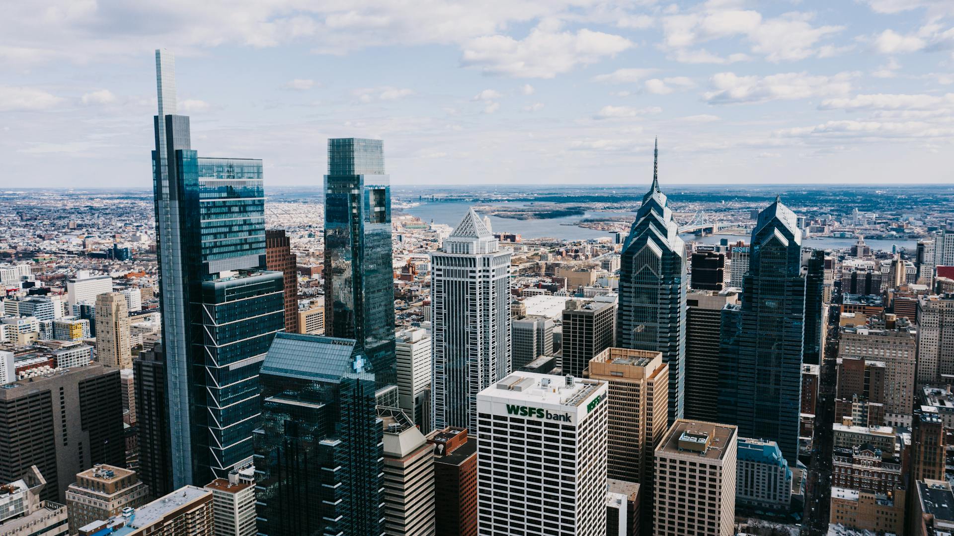 Drone view of modern tall buildings of business centers and offices under tranquil cloudy sky