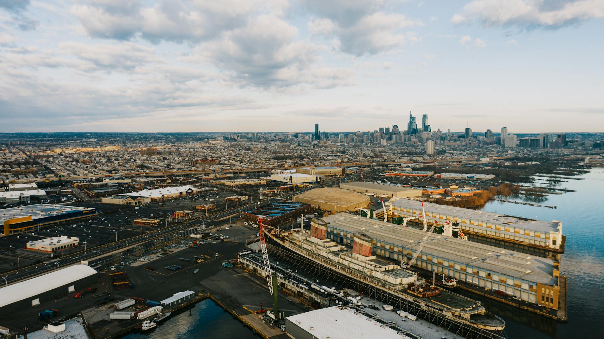 Stunning aerial view of the industrial port and Philadelphia skyline at dusk.