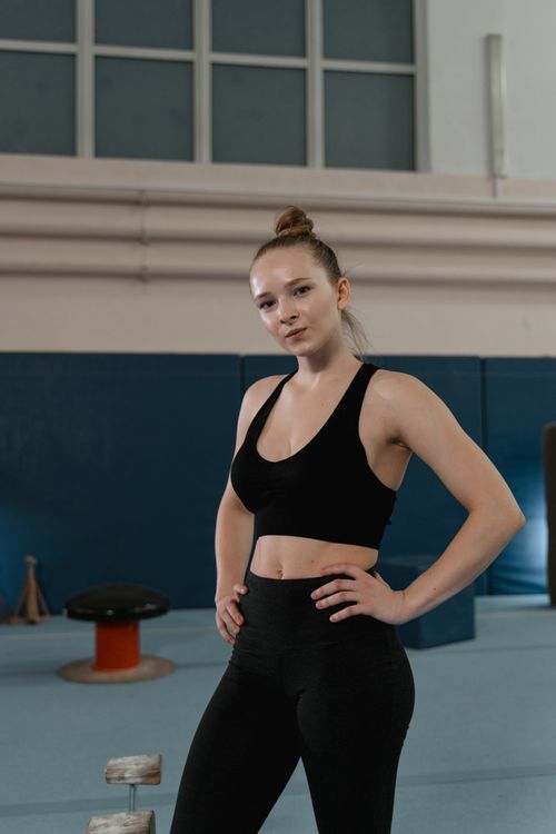 Free A confident female athlete posing indoors in sportswear, exuding strength and focus. Stock Photo