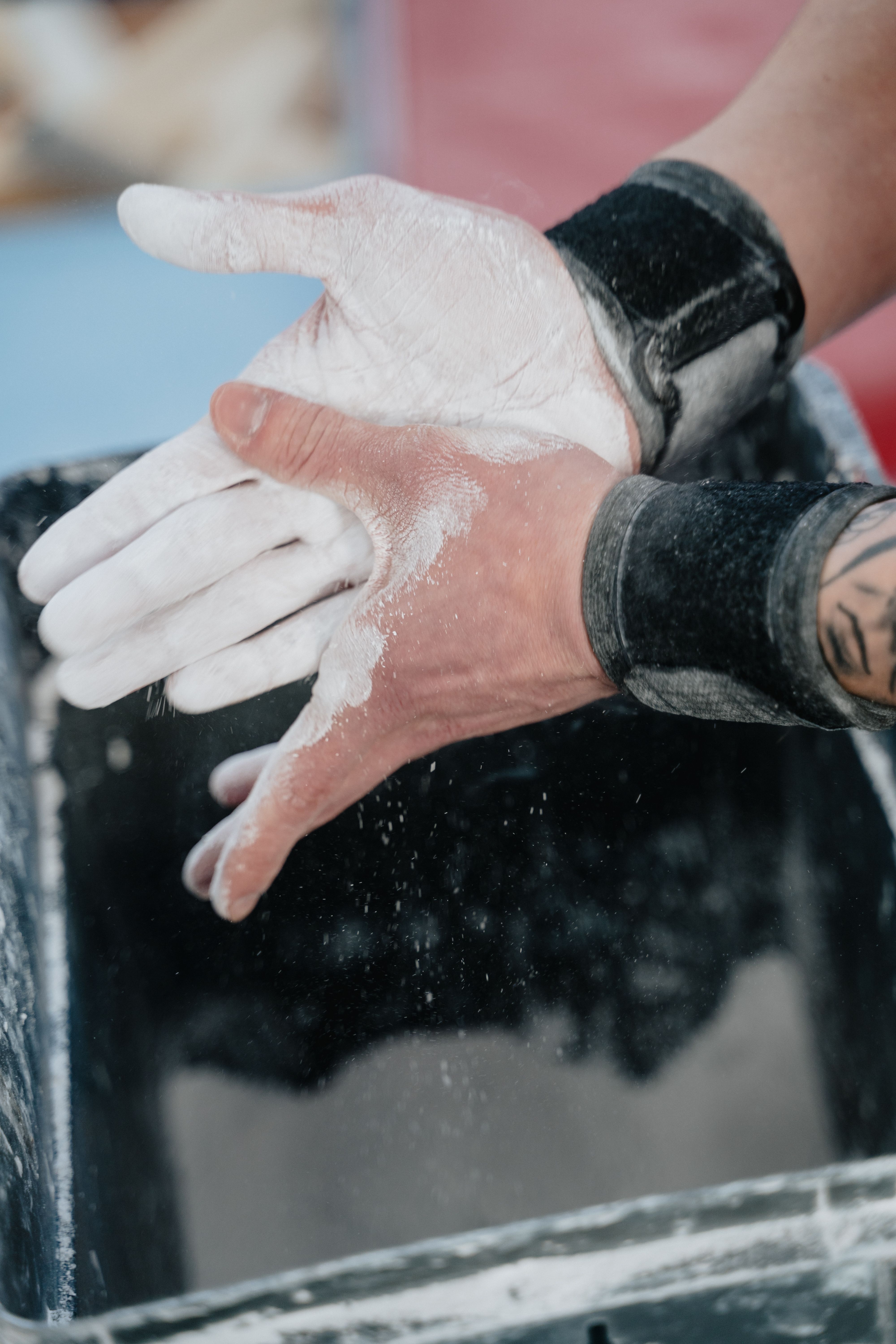 Close-up of hands applying chalk powder before physical workout for better grip.
