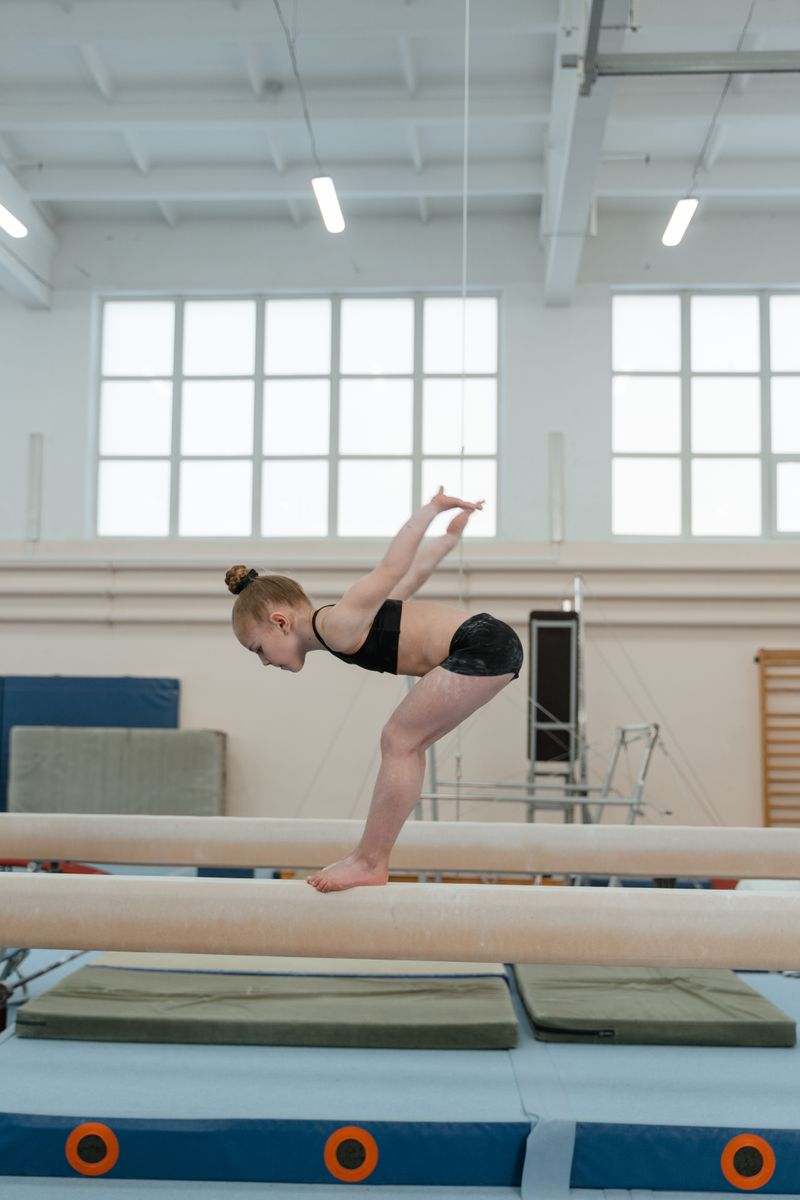 Young gymnast practising poise on a balance beam