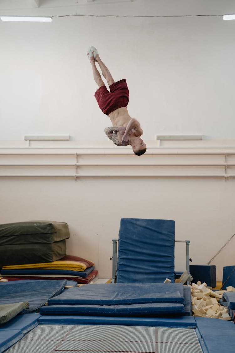 A Man Doing Gymnastics On A Trampoline