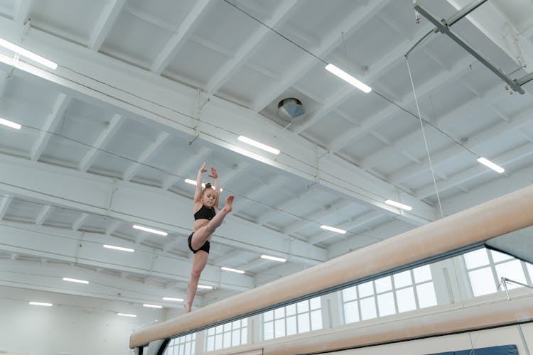 A Young Girl Balancing On Balance Beam