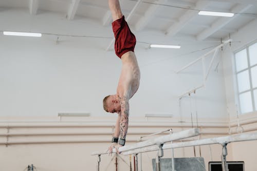 A Man Doing Hand Stand on Parallel Bars