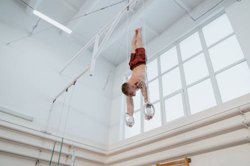 Photo of a Man Gymnast Practicing on Gymnastic Rings