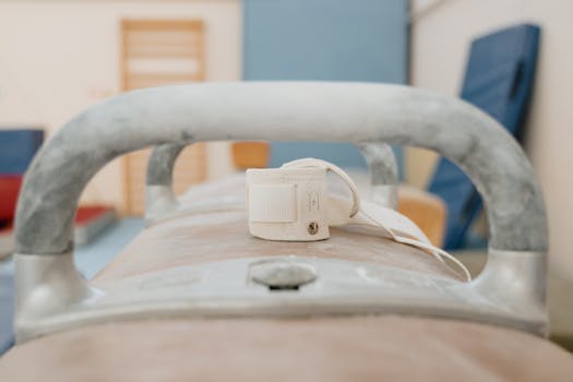 Detailed view of a pommel horse with wrist wraps, ideal for sports and gymnastics themes.